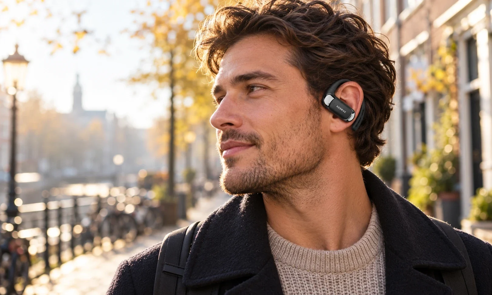 Man met een REBØNE open-ear oordopje op een Amsterdamse gracht